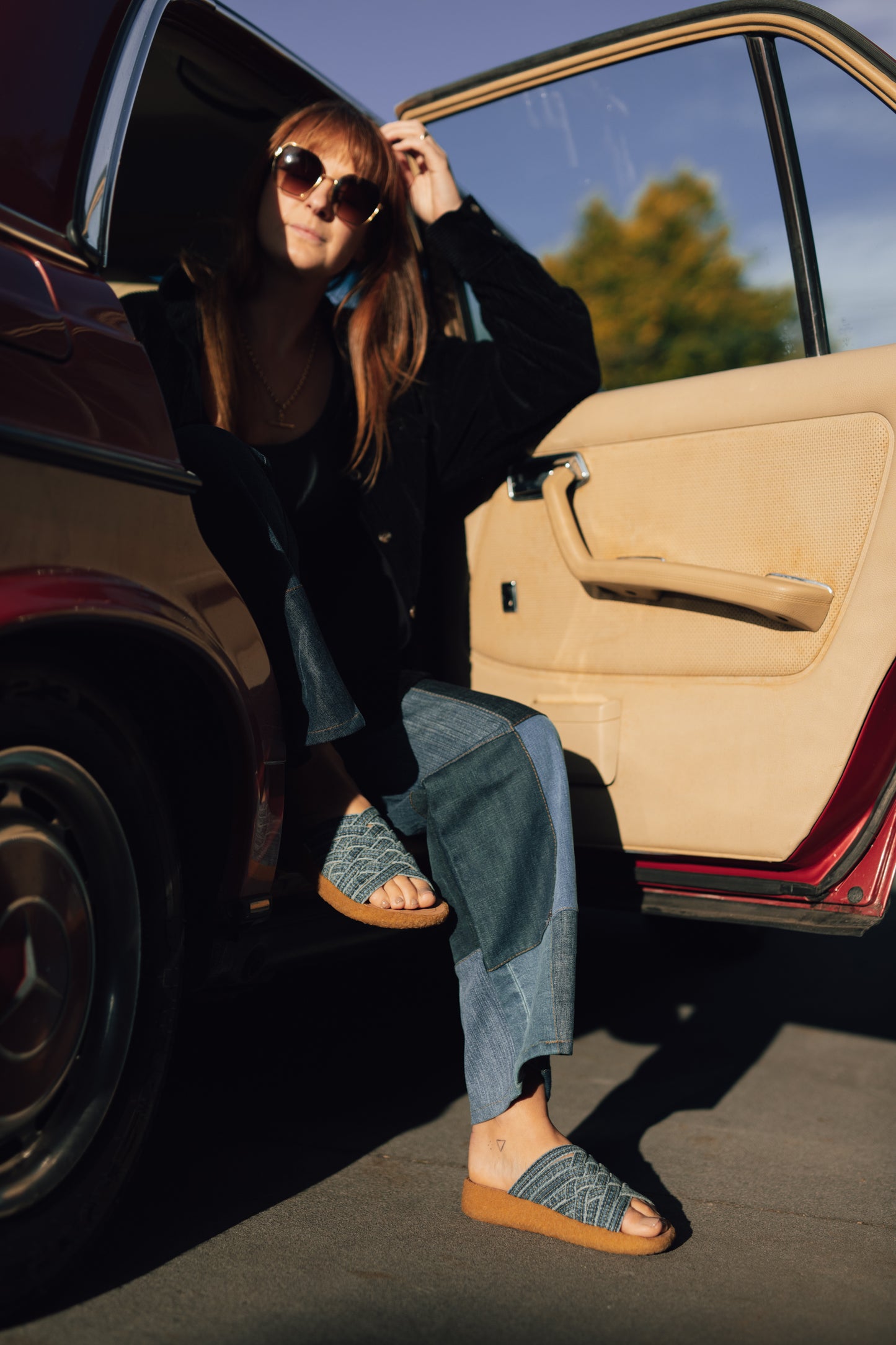 Women wearing collaborative orSlow x Malibu Sandals washed indigo Zuma with crepe sole with feet outside of vintage Mercedez Benz car