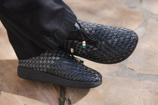 Close up photo of all new Malibu Sandals Matador Low Woven chukka in all black with beads at the tips of the laces