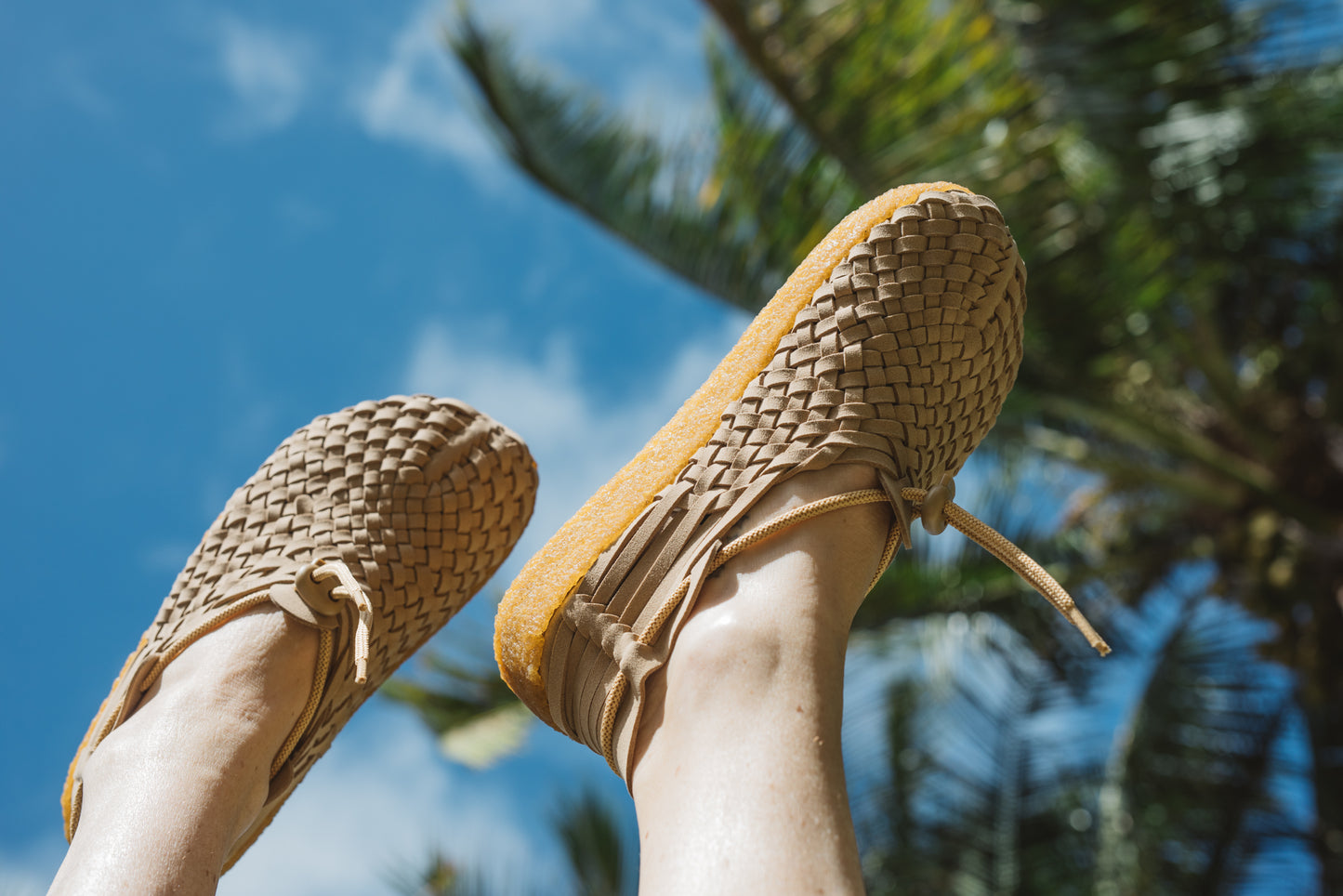 Close up photo of feet pointed up in the sky while wearing Latigo Moc in walnut vegan suede and crepe sole 